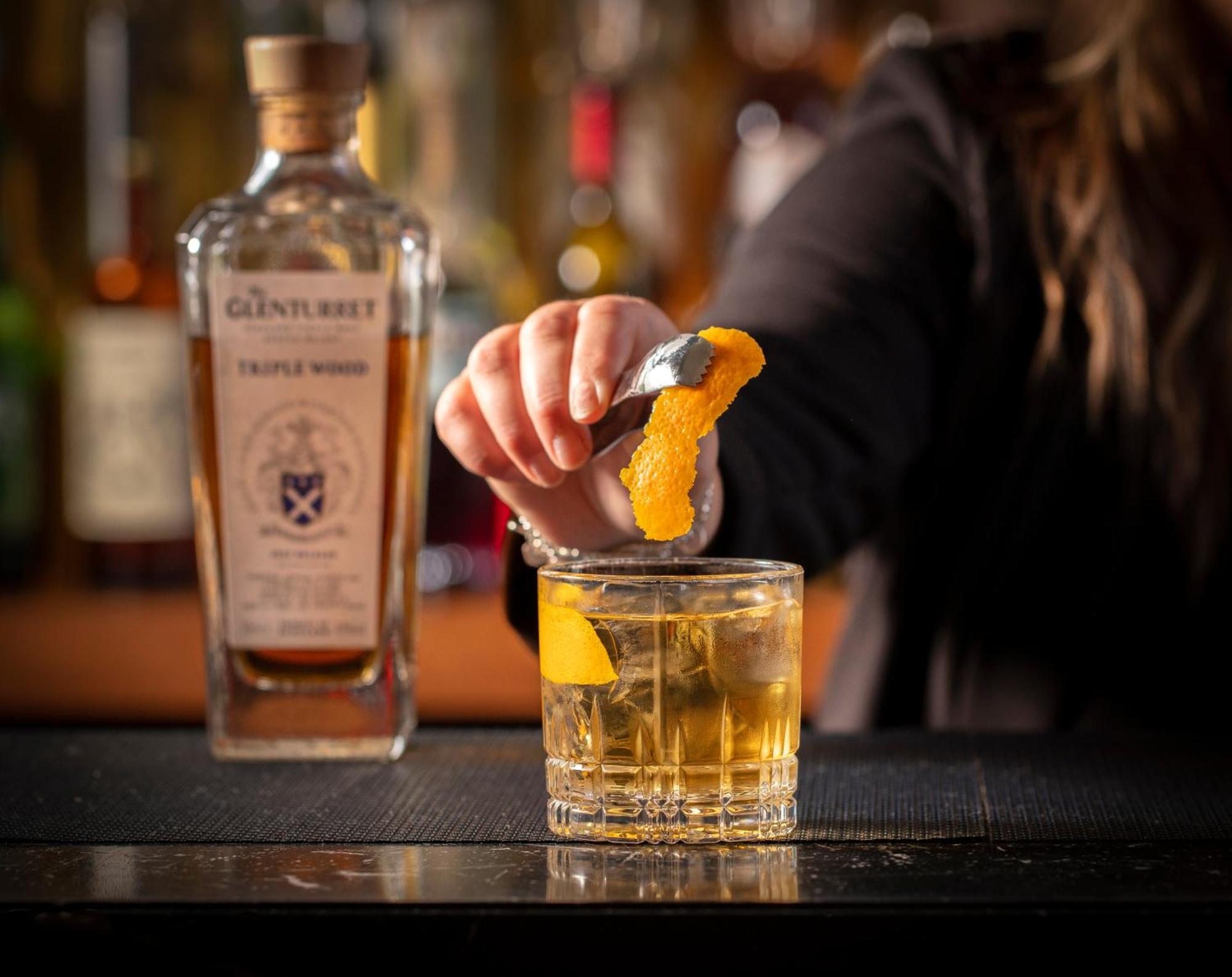 Schloss Roxburghe, Part Of Destination By Hyatt Екстер'єр фото A bartender adding a lemon twist to a glass of GINfinity